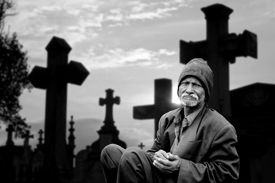 Einsamer Mann am Friedhof